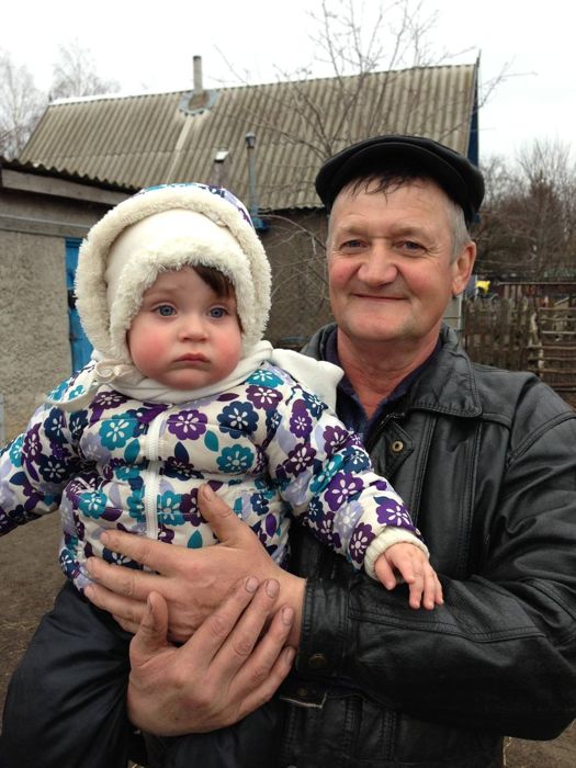 Дедушка держит малышку на руках
