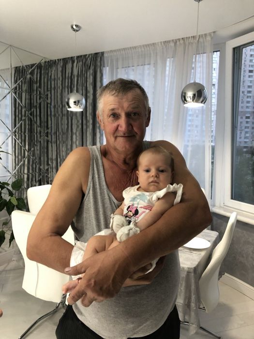 Дедушка держит на руках малышку